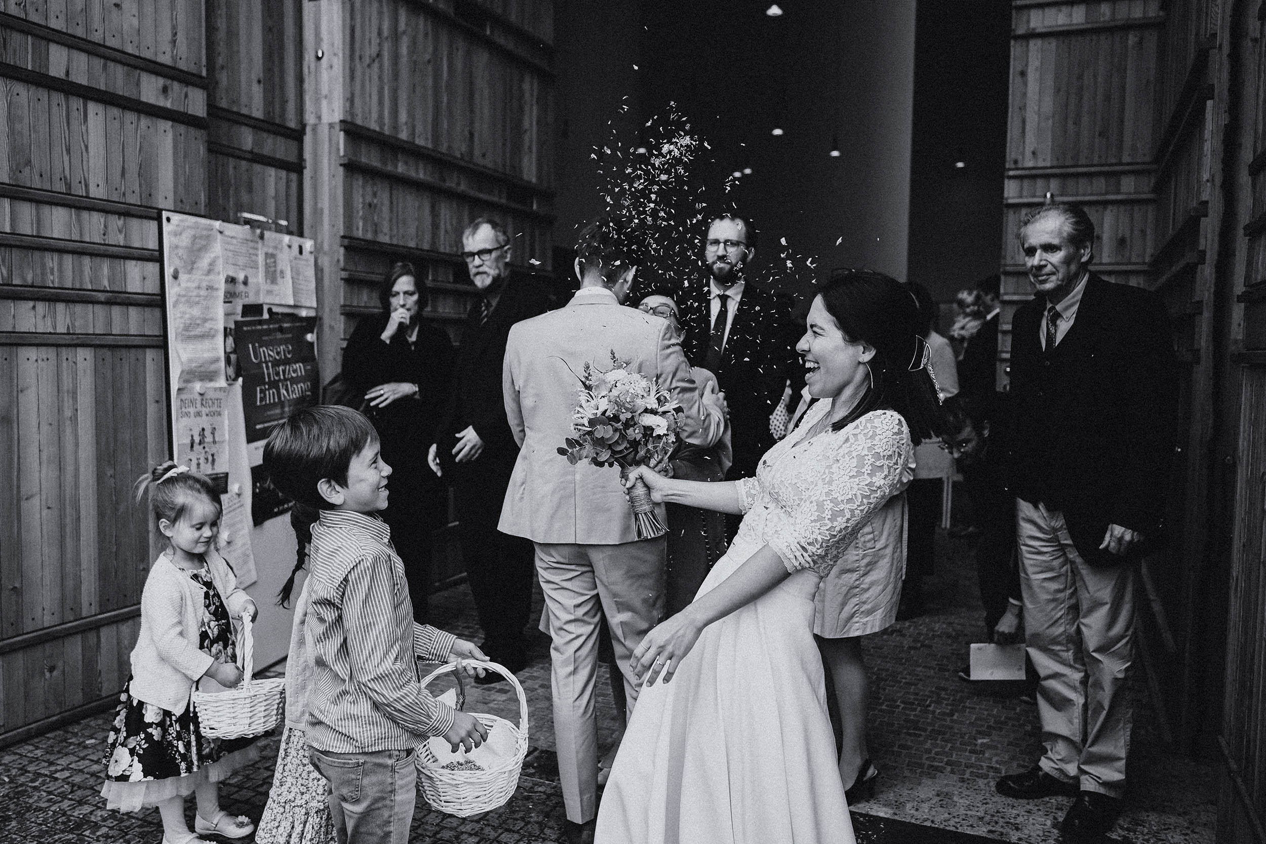 Ein Schwarz-Weiß-Foto einer Braut und eines Bräutigams vor einem Gebäude.